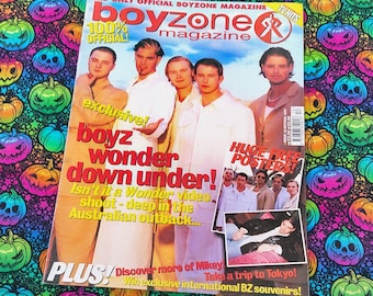 May include: A vintage Boyzone magazine cover with the text "boyz wonder down under!" and "100% official!" The magazine features a group of men in white shirts and a smaller image of the group. The background is a colorful Halloween-themed pattern.