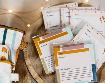 May include: A set of printable cards with a light pink, yellow, and blue geometric design. The cards have the words "Verse" and "Scripture" printed on them, with lines for writing. The cards are in a wooden bowl.