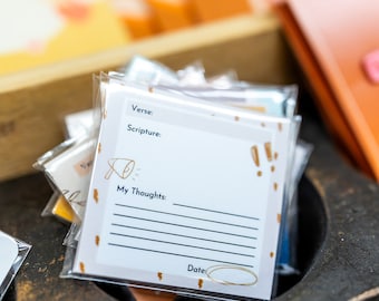 May include: A stack of white cards with a gold and white design. The cards have the words "Verse", "Scripture", "My Thoughts", and "Date" printed on them. The cards are in a wooden box.