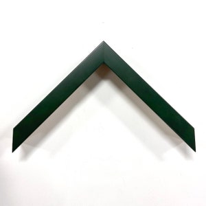 May include: A dark green picture frame with a beveled edge. The frame is made of wood and has a matte finish.