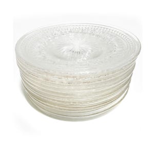 May include: A stack of clear glass plates. Each plate has a decorative, raised pattern around the rim and a central design. The plates are stacked neatly, showcasing their transparent quality and intricate detailing.