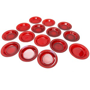 Può includere: Un set di 15 piatti in vetro rosso, disposti a semicerchio su uno sfondo bianco. I piatti sono tutti della stessa dimensione e forma, e hanno un bordo leggermente rialzato.