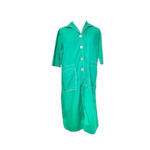 Puede incluir: Un vestido largo de botones verde azulado con costuras blancas y dos bolsillos. El vestido tiene cuello y mangas cortas.