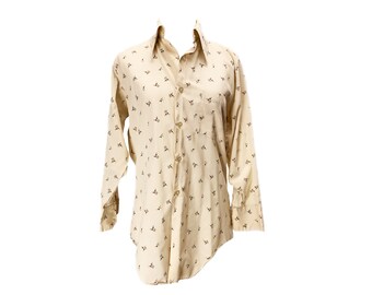 May include: A beige long-sleeved button-down shirt with a small floral print.
