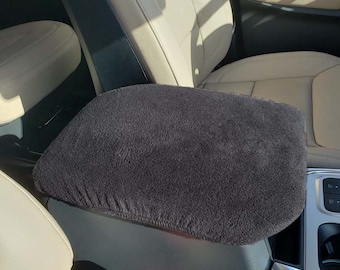 May include: Black fleece car seat armrest cover. The cover is soft and plush, and it fits snugly over the armrest.