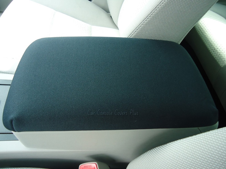 以下が含まれることがあります： 「Car Console Covers Plus」という文字が印刷された黒い車のコンソールアームレストカバー