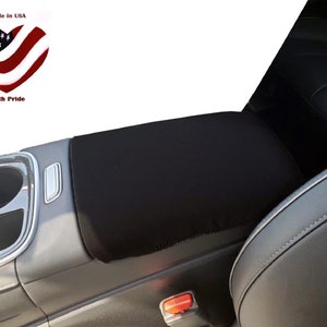 May include: Black car seat armrest cover with a black fabric cover. The cover is made of a soft, durable material and is designed to protect the armrest from wear and tear. The cover is easy to install and remove, and it can be machine washed.