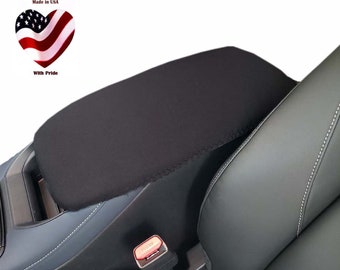 May include: Black car seat armrest cover. The cover is made of a soft, black fabric and is designed to protect the armrest from wear and tear.  Made in USA with pride.