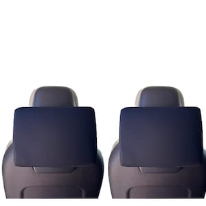 May include: Two car seat headrest covers in a dark blue color. Each cover is rectangular and appears to be made of a soft, padded material. The headrests are attached to dark gray car seats, set against a white background.