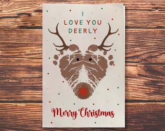 May include: A Christmas card with a reindeer made from brown footprints. The reindeer has a red nose and the text "I love you deerly" and "Merry Christmas" in red.