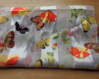 May include: White sheer scarf with a striped pattern and a floral design featuring butterflies in shades of red, yellow, and black.