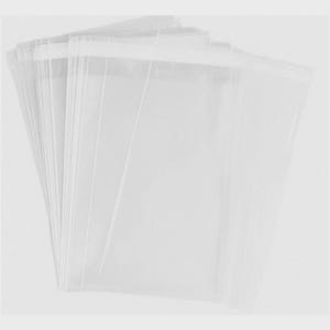 May include: A stack of clear, transparent cellophane bags. The bags are rectangular with a sealed bottom and open top. The bags are arranged in a fan shape, with the open tops facing upwards. The background is a solid, light gray color.