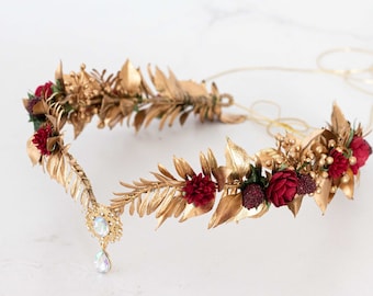 May include: Gold leaf and burgundy flower crown with a crystal teardrop pendant. The crown is made of wire and has a delicate, romantic look.