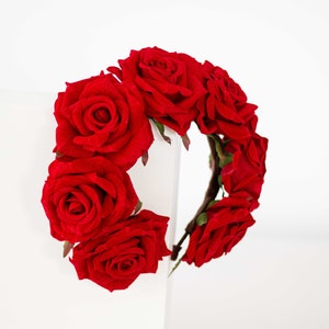 May include: A red rose flower crown headband. The headband is made of a flexible wire base and is decorated with red roses.