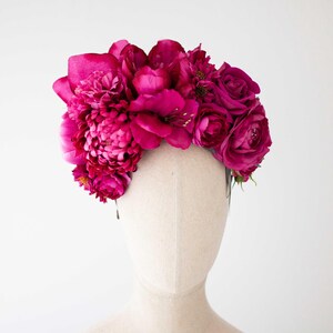 Può includere: Una corona floreale rosa fatta di fiori di seta. La corona è fatta di rose e peonie.