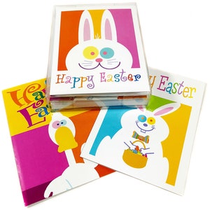 May include: A set of colorful Easter cards featuring cartoon bunnies and a duck. The cards have a white background with the words "Happy Easter" in various colors. The cards are in a clear plastic box.