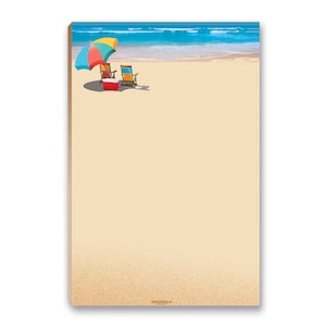 May include: A notepad featuring a beach scene with a colorful umbrella, two beach chairs, and a red cooler. The top of the notepad shows a blue ocean and a sandy beach. The notepad has a sandy background.