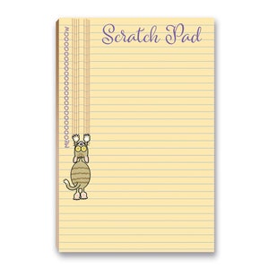May include: A yellow lined notepad with the text "Scratch Pad" in purple cursive. A cartoon cat with brown and white stripes is hanging from the top of the notepad.