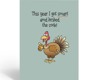 May include: A greeting card with a cartoon turkey illustration. The turkey is brown, red, and yellow, giving a thumbs-up. Text on the card reads, "This year I got smart and bribed the cook!" The card has a light blue background.