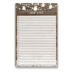 May include: A rustic wooden notepad with a white background and a lace border. The notepad has a title that says "The List" and is decorated with string lights and mason jars.