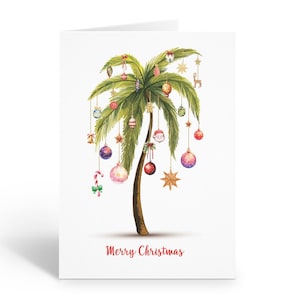 May include: A Christmas greeting card featuring a watercolor illustration of a palm tree decorated with ornaments. The tree is adorned with colorful baubles, stars, and a candy cane. The words "Merry Christmas" are written in red script at the bottom.