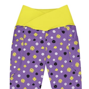 May include: Purple leggings with a yellow waistband and a pattern of black and yellow dice.