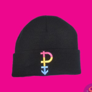 Pode incluir: Gorro preto com um símbolo de orgulho pansexual bordado colorido na frente. O símbolo apresenta cores rosa, amarelo e azul. O gorro é feito de malha.