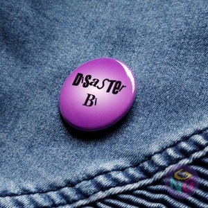 disaster bi button on blue denim background