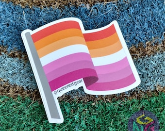 May include: A lesbian pride flag sticker with a white background and five horizontal stripes in the colors red, orange, yellow, pink, and purple. The sticker has the text "@queerestgear" printed on it.