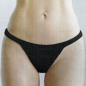 May include: A black bikini bottom crafted from a textured crochet knit fabric. The garment features a low-rise waistline and a classic cut design with thin side straps, showcasing a consistent, repeating stitch pattern throughout the entire piece.