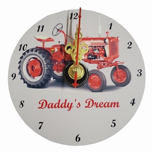 May include: Red and grey tractor clock with black numbers and the text "Daddy's Dream".