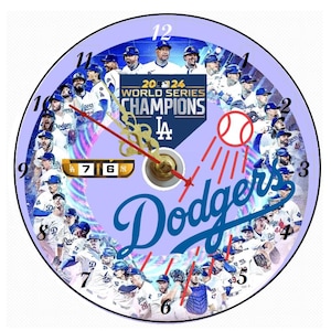 May include: A purple and blue circular clock with a white background. The clock face features a collage of Los Angeles Dodgers baseball players from the 2024 World Series Championship team. The clock hands are gold and the numbers are black. The text "2024 World Series Champions" and "LA" are displayed in the center of the clock face. The text "Dodgers" is displayed in a large blue font at the bottom of the clock face.
