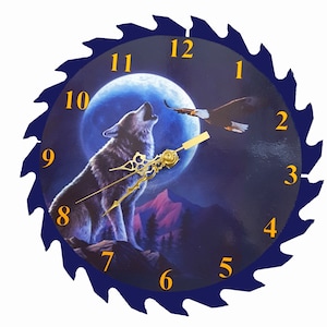 May include: A blue circular saw blade clock with a wolf howling at the moon and an eagle flying in the background. The clock face has Roman numerals and gold hands.