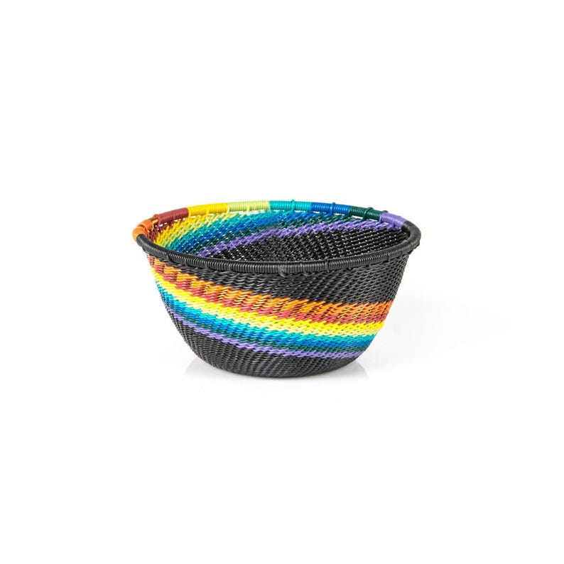 May include: A round, woven basket with a black base and a rainbow of colors. The basket's rim is lined with a vibrant array of colors, including red, orange, yellow, green, blue, and purple. The basket is made of a durable material.