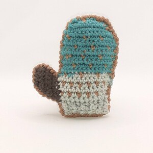 May include: A crocheted mitten with a brown cuff and a blue and white pattern.