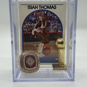 Ensemble de bagues commémoratives et de trophées du championnat NBA 1990 des Detroit Pistons, avec carte Isiah Thomas