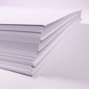 Puede incluir: Una pila de papel blanco, cuidadosamente alineada, con el borde superior ligeramente inclinado. El papel es liso y parece nuevo.