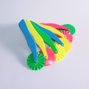 May include: Set of five colourful plastic pastry cutters with different shaped wheels. The cutters are yellow, green, blue, pink, and green.
