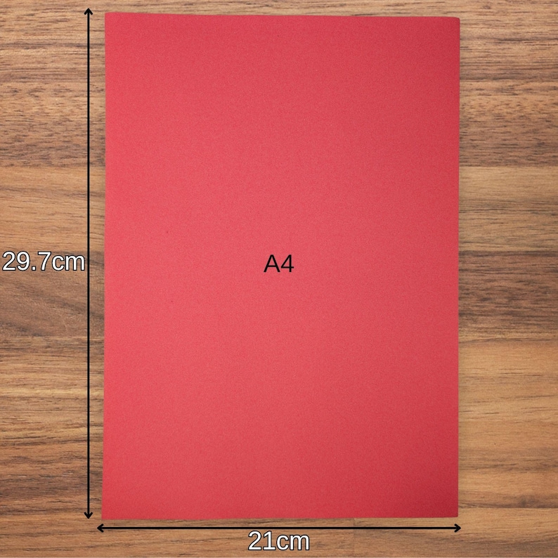 May include: A rectangular sheet of red paper labelled A4 in the centre. The paper is measured with arrows indicating a height of 29.7 cm and a width of 21 cm. The surface of the paper appears flat and solid red, providing a clear visual reference for size.