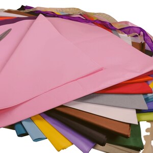 May include: A stack of tissue paper in various colors, including pink, red, gray, blue, yellow, purple, brown, black, and green. The tissue paper is folded and arranged in a fan shape.