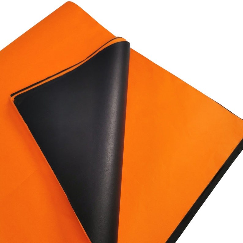 May include: A bright orange fabric sheet with a black backing. The sheet is folded over, revealing the black backing.