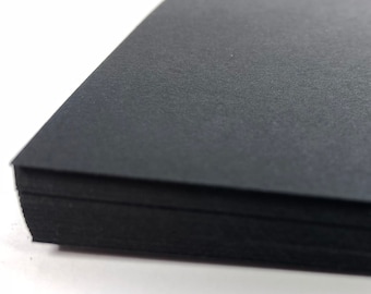 Könnte beinhalten: Ein Stapel schwarzes Kartonpapier. Das Papier hat eine strukturierte Oberfläche.
