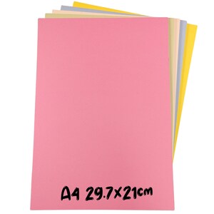 May include: A stack of A4 size colored paper sheets in pink, yellow, green, and blue. The pink sheet is in the foreground, with the text "A4 29.7x21cm" in black. The paper is 8.3 x 11.7 inches.