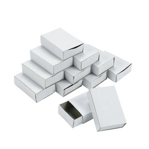 May include: A stack of white cardboard boxes with a drawer-like opening on the front. The boxes are arranged in a pyramid shape, with the top box slightly open.