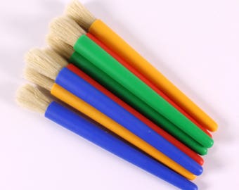 Könnte beinhalten: Ein Satz mit sechs Pinseln mit bunten Griffen. Die Griffe sind gelb, rot, grün und blau. Die Pinsel haben weiße Borsten.