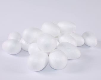 Könnte beinhalten: Ein Haufen weißer Styropor-Eier. Die Eier sind glatt und rund und alle gleich groß.