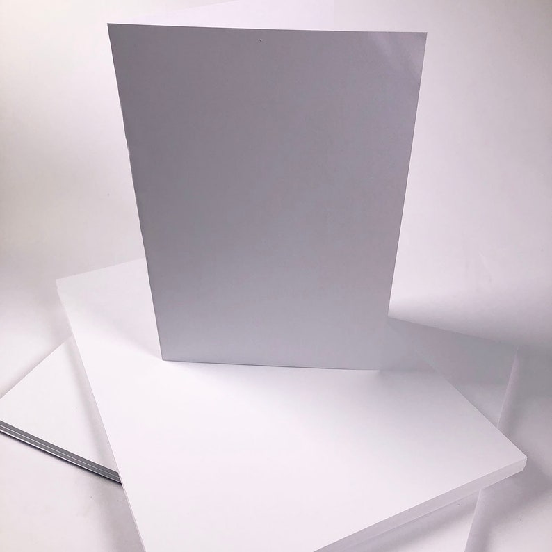 Puede incluir: Una pila de papel de cartulina blanca. La hoja superior est&aacute; de pie.