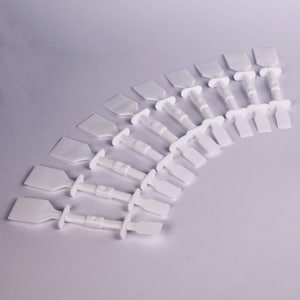 May include: A group of white plastic tag fasteners, each with a paddle-shaped head, a cylindrical body, and a T-shaped base. They are arranged in a semi-circle on a white background.