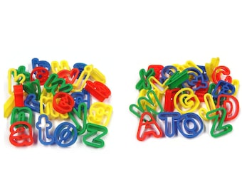 Könnte beinhalten: Ein Set bunter Kunststoff-Alphabet-Keksstempel. Die Stempel sind in verschiedenen Farben, darunter Rot, Gelb, Blau und Grün. Sie sind in einem Stapel angeordnet, wobei einige Buchstaben sichtbar sind.