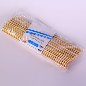 May include: A clear plastic bag filled with 100 natural wooden craft sticks. The bag has a label that reads "Art, Craft & Collage Round Wooden Craft Sticks Pack of 100".